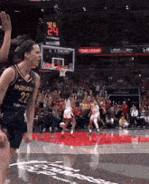 a female basketball player for the indians stands on the court