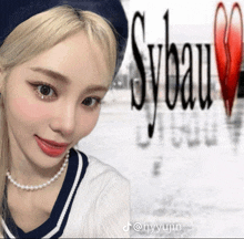 a woman wearing a pearl necklace stands in front of a sign that says sybeau