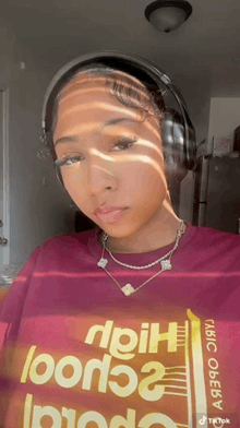a woman wearing headphones and a t-shirt that says " high "