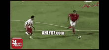a group of soccer players on a field with the website ahlyo7.com