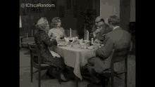 a woman is sitting at a table with candles and a glass of wine ..