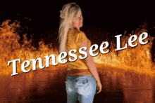 a woman in a yellow shirt is standing in front of a fire with the name tennessee lee written on it