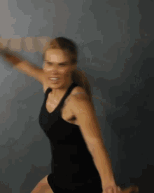 a blurry photo of a woman in a black tank top and shorts