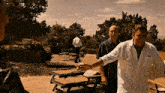 a man in a white shirt shakes hands with another man in a black shirt