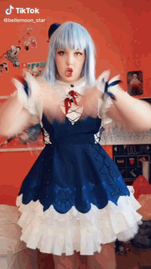 a girl in a blue and white dress is making a funny face