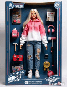 a barbie doll in a pink hoodie and ripped jeans is in a box