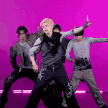 a group of young men are dancing in front of a purple backdrop