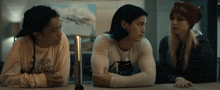 three girls sitting at a table with one wearing a shirt that says read on it