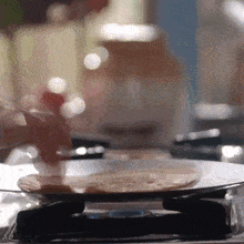 a close up of a person cooking food on a stove top