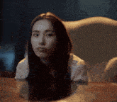 a woman sitting at a table with a reflection of herself in the table