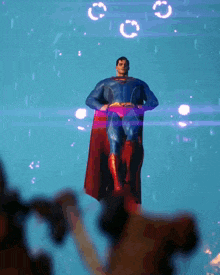 a man in a superman costume is standing in the air