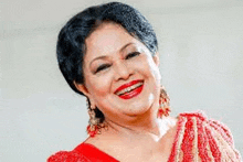 a close up of a woman wearing a red dress and red lipstick smiling .