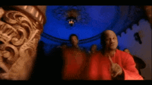 a man in a red shirt is pointing his finger
