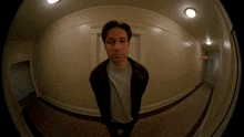 a man stands in a hallway with a fisheye lens