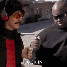 a man with a mustache and sunglasses is pointing at another man with the word lock in written on the bottom