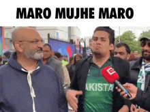 a man in a green pakistan shirt is being interviewed by a reporter