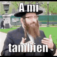 a jewish man with a beard and glasses is wearing a hat and a suit and says a mi tambien .