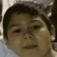 a close up of a young boy 's face with a blurred background .