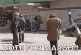 a man is doing a handstand in front of a gas station and a sign that says vote for margo .