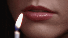 a close up of a woman 's lips with a candle in front of her