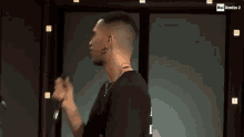 a man is holding a microphone in his hand and singing into it .