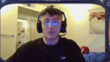 a man wearing headphones and glasses looks at the camera