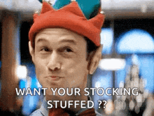 a man wearing a christmas elf hat and bow tie is making a face .