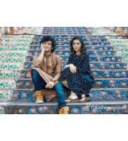 a man and a woman are sitting on a set of stairs ..