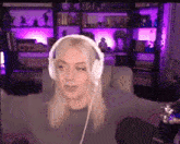 a woman wearing headphones is sitting on a couch in front of a microphone .