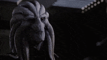 a man is looking at a statue of a monster with long horns
