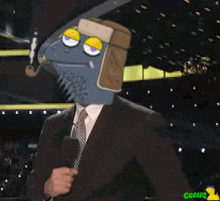 a man in a suit and tie is holding a microphone with a cartoon fish on his head
