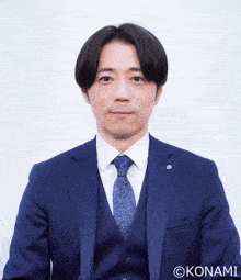a man in a suit and tie has the watermark konami on his photo