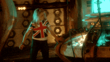 a woman wearing a british flag shirt stands in a room