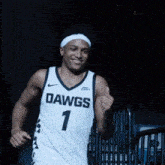 a man wearing a dawgs jersey is smiling