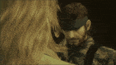 a man with a beard and a headband looks down at a woman
