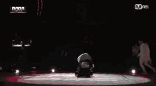 a man is dancing on a stage in front of a mnet sign .