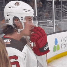 a hockey player wearing a white helmet and red gloves