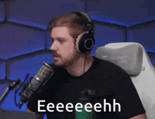 a man wearing headphones is sitting in front of a microphone and says eeeeehhh .