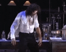 a man in a white shirt and black pants is dancing in a room .