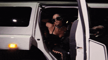 a woman is getting out of a white limousine