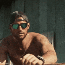 a shirtless man wearing sunglasses and a baseball cap is running .