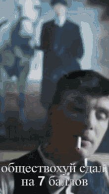a man in a suit is smoking a cigarette in a blurry photo with russian writing