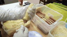 a person is preparing food in a plastic container with the words made in animotica on the bottom
