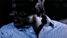 a close up of a man 's face in a blue shirt .