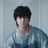 a young man wearing a blue sweater with the word slam on it