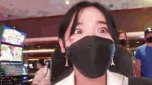 a woman wearing a mask and earrings with the letter a on it