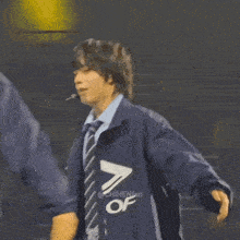 a blurry picture of two men standing next to each other with one wearing a jacket with the letter a on it