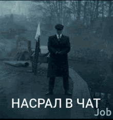 a man in a suit and hat is standing in front of a sign that says job on it
