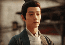 a man with a bun on his head and a white shirt