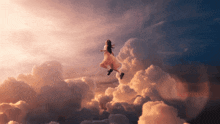 a woman in a dress is flying through the clouds